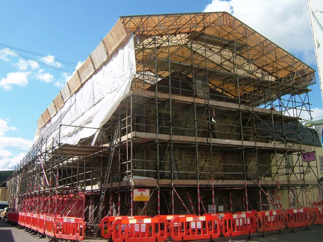 A large building under construction surrounded by scaffolding.