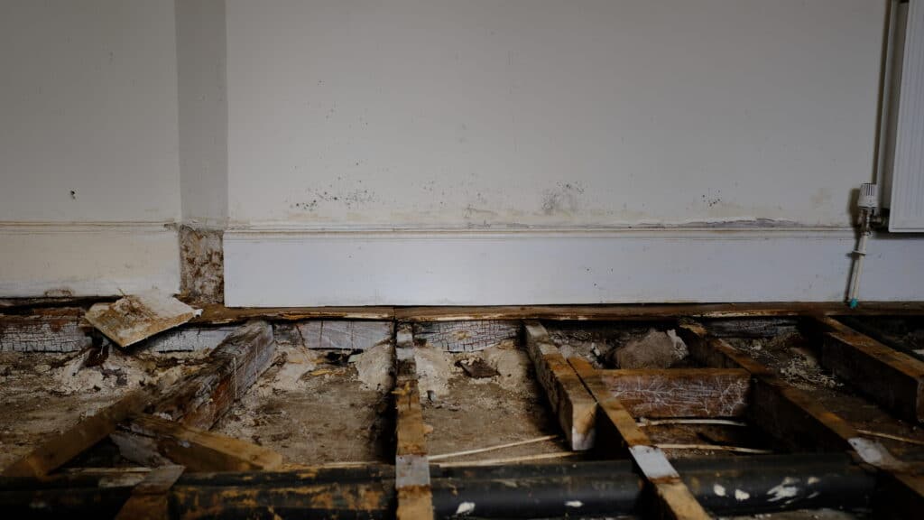 A room with an old, damaged wooden floor.