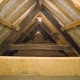 Interior of the Old Duchy Palace roof with wooden beams, dimly lit by two lights.
