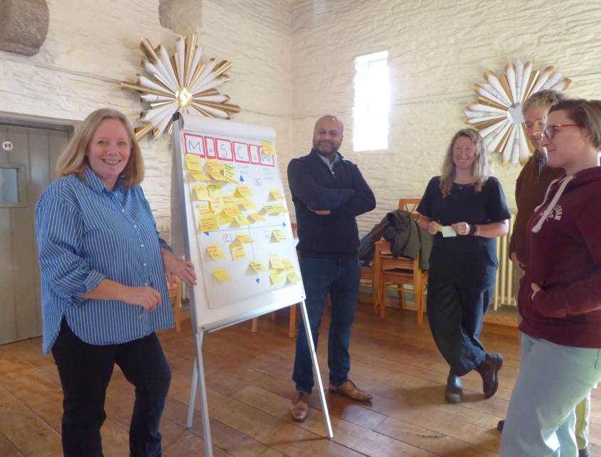 A group of trustees standing around a white board.